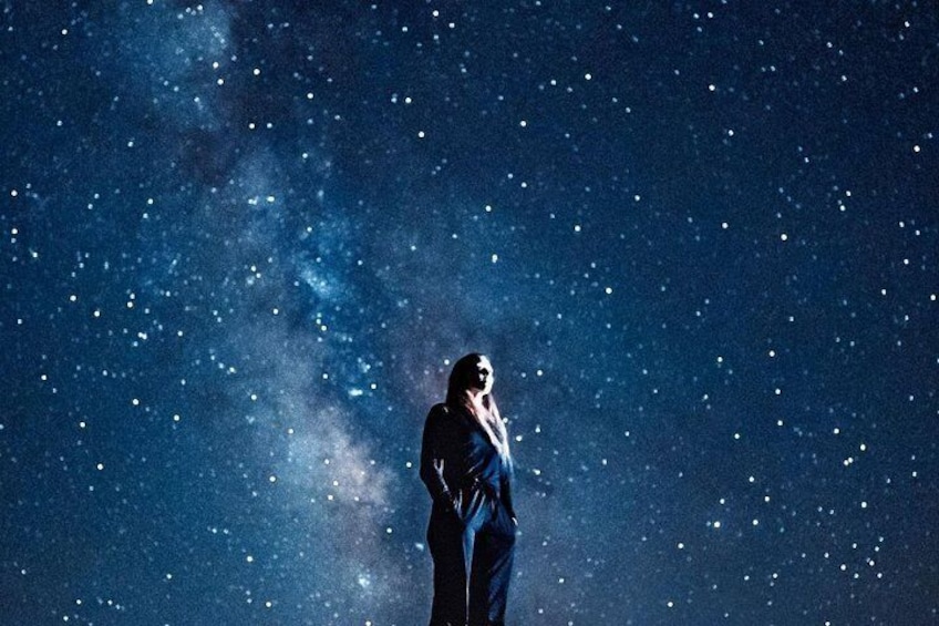 A person standing under a starry night sky. 2