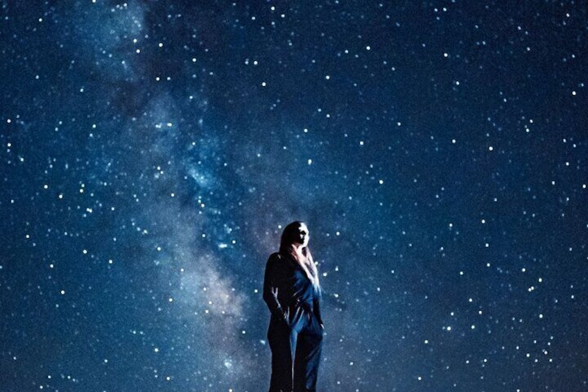 A person standing under a starry night sky. 2