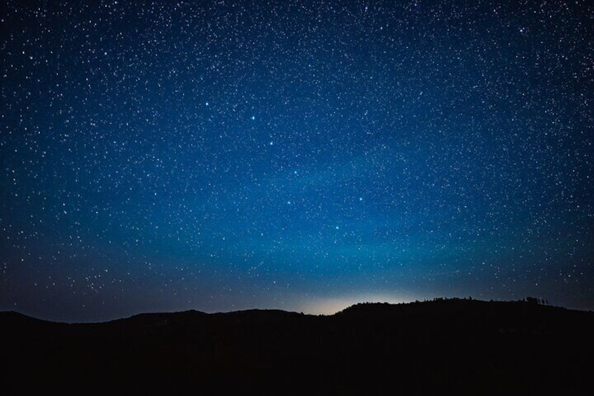 A starry night sky over a hilly landscape. 4