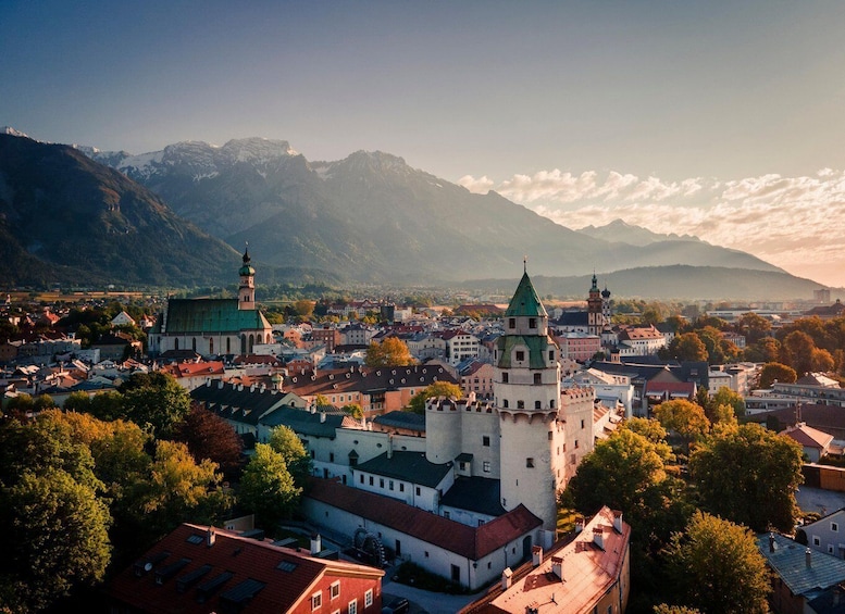 A town with historic architecture, including a prominent church with a green roof and a castle-like structure with a green spire. 1