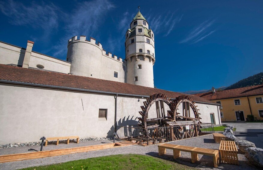 A historic building with a water wheel and a tower. 5