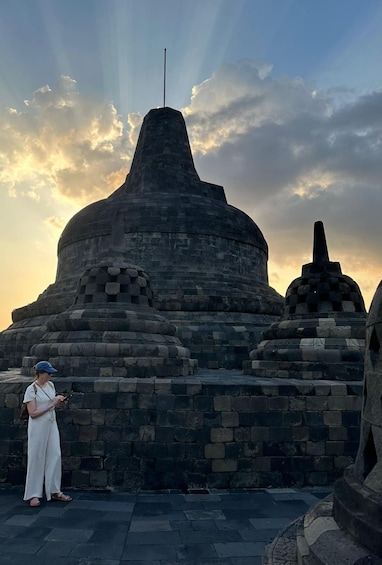 A stone structure with a pointed top and a person standing in front. 3