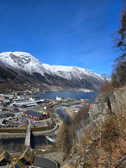 A mountainous landscape with a town, a river, and a body of water. 2