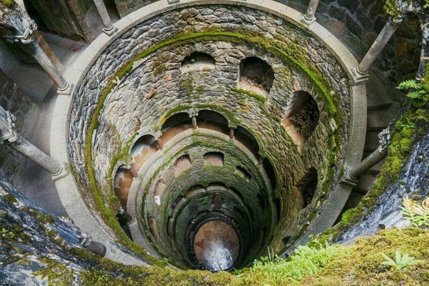 Una scala in pietra a chiocciola con muschio, che conduce a un punto centrale. 3