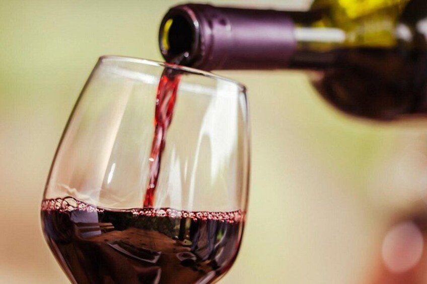 Un bicchiere da vino che viene riempito di vino rosso. 1