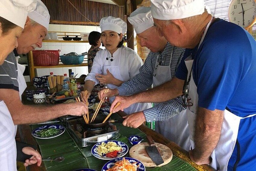 A group of people cooking at a market stall. 5