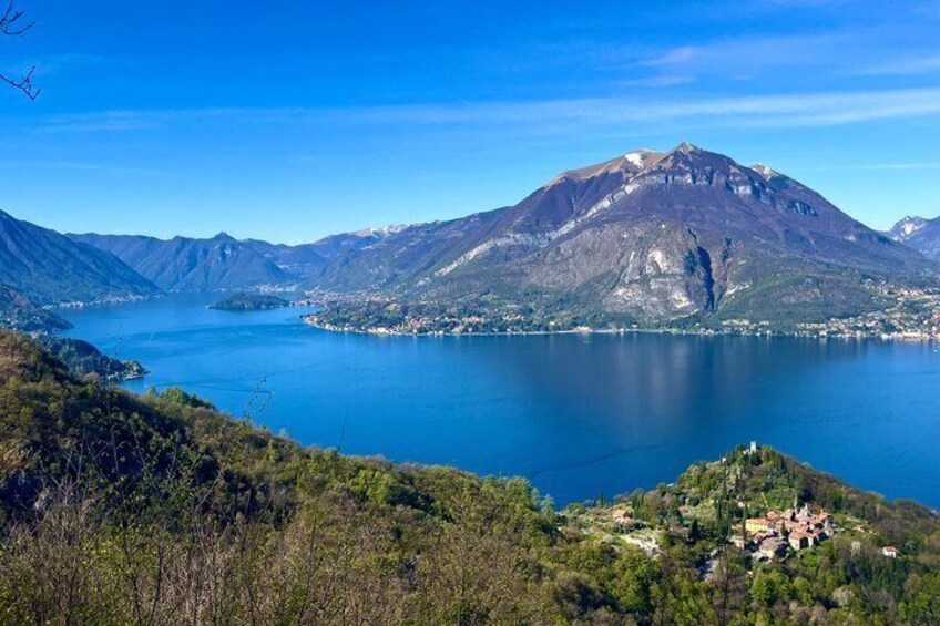 A mountain lake with a prominent peak, a small settlement, and surrounding hills. 5