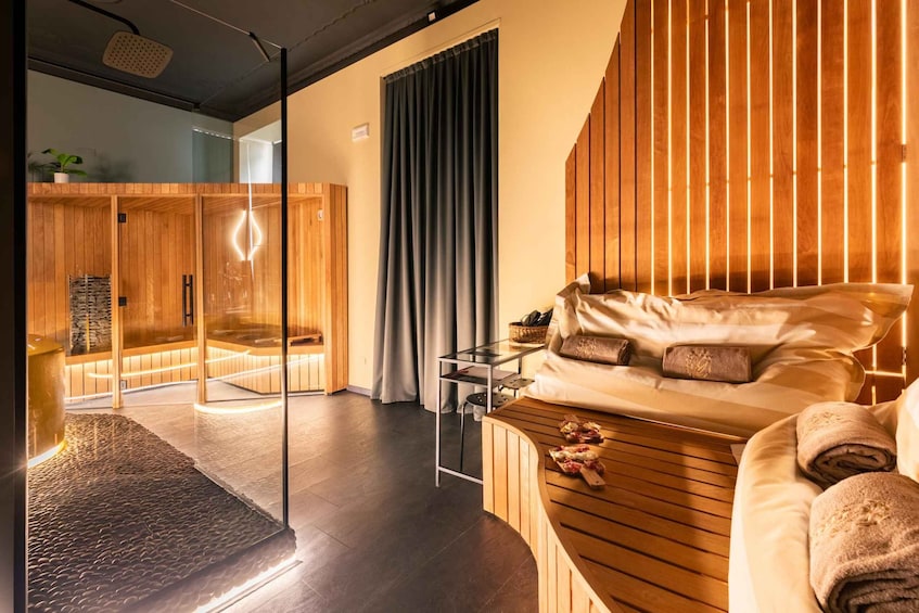 A modern bedroom with a wooden bed, a glass shower, and a wooden wardrobe. 1