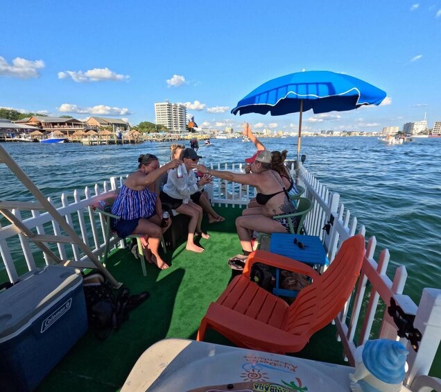 A group of people on a boat with a white fence, a blue umbrella, and a cityscape in the background. 3