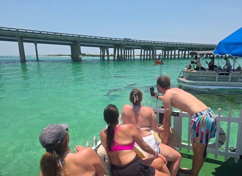 A group of people on a boat near a pier with clear turquoise water. 5