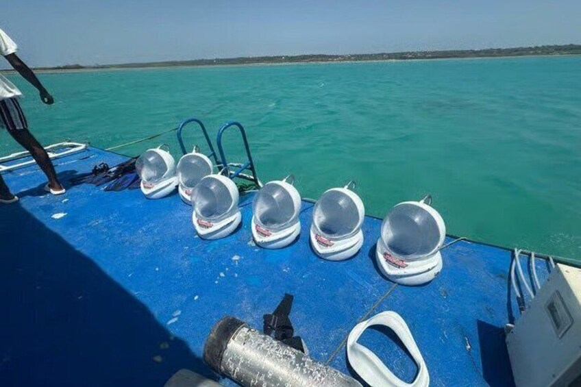 Ein Boot mit mehreren Taucherhelmen, die auf dem Deck aufgereiht sind. 4