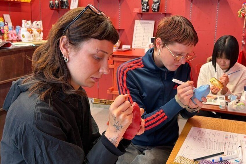 Two people sitting at a table, one eating and the other using a smartphone. 1