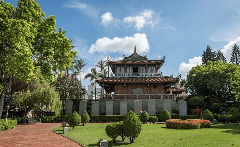 A traditional pagoda-style building surrounded by well-maintained gardens and trees. 1