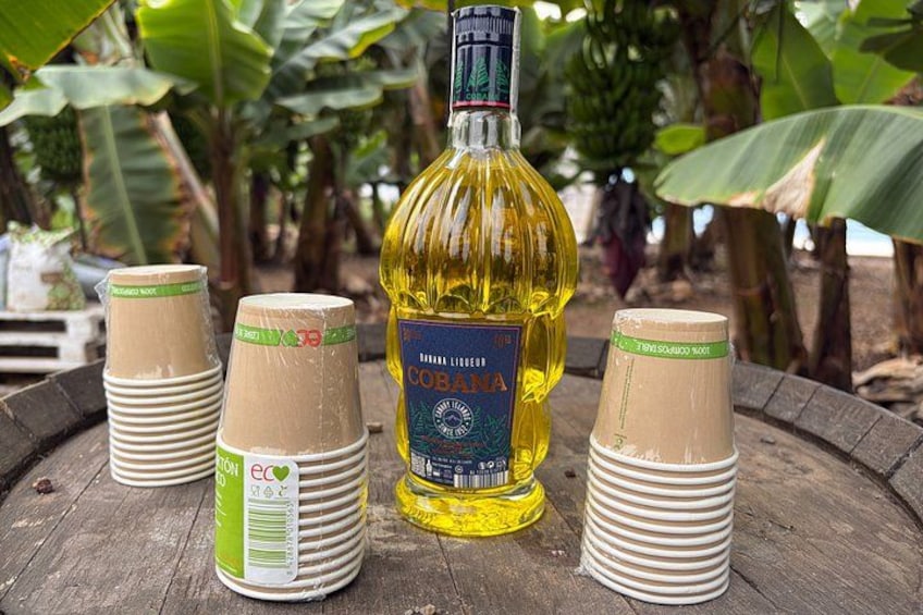 A bottle of Cobalt 37% alcohol, surrounded by stacks of paper cups on a wooden barrel. 3