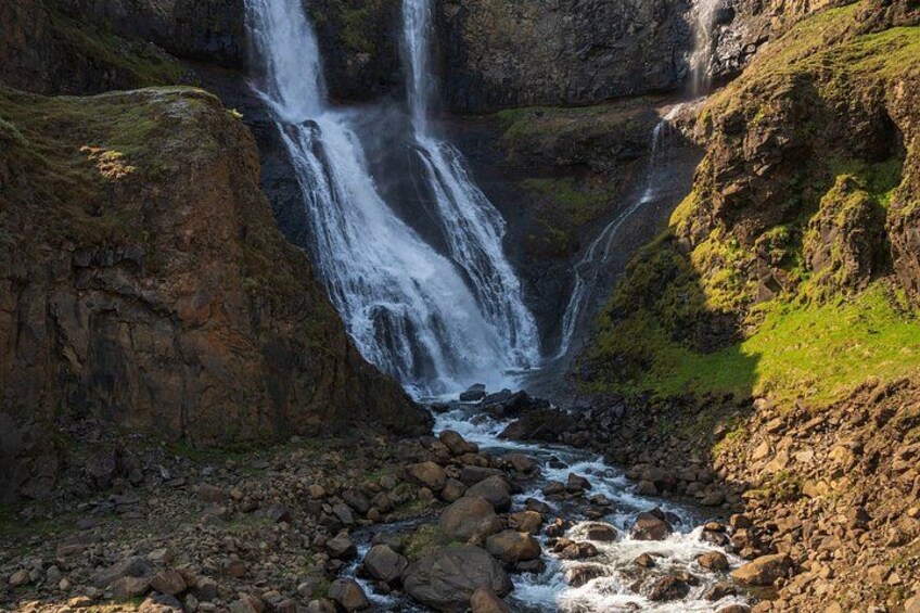 A waterfall cascading down a rocky cliff into a river. 4