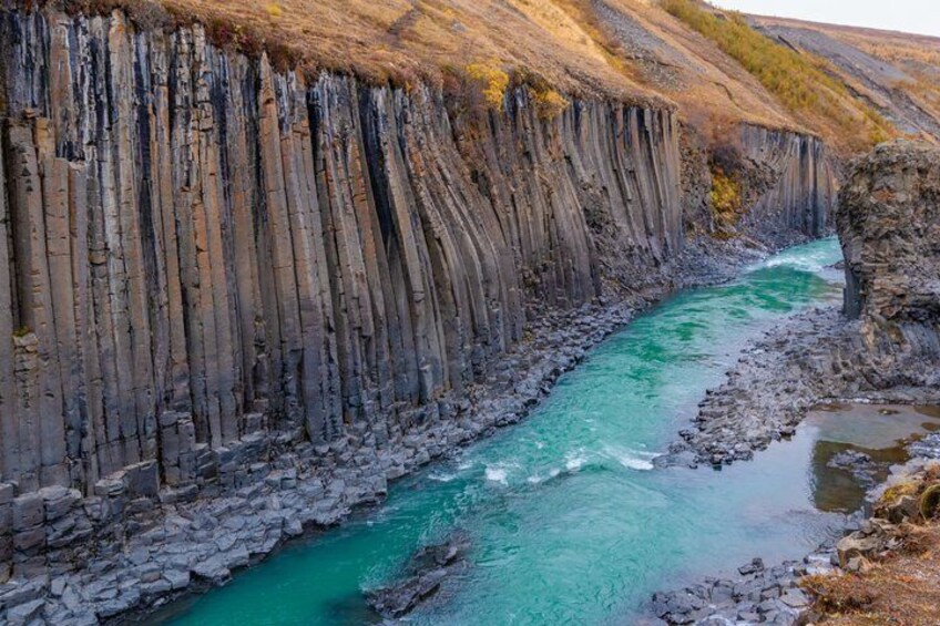 A river flowing through a canyon with steep, vertical rock walls. 1