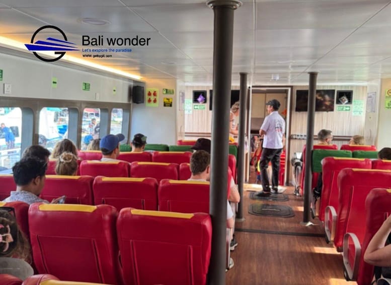 A ferry interior with red seats and a person standing near the aisle. 3
