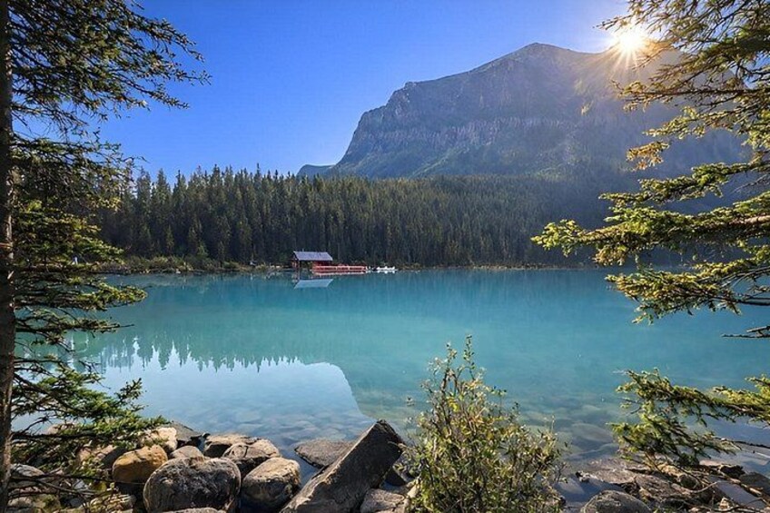 A clear lake with a mountain in the background, surrounded by trees and rocks. 1