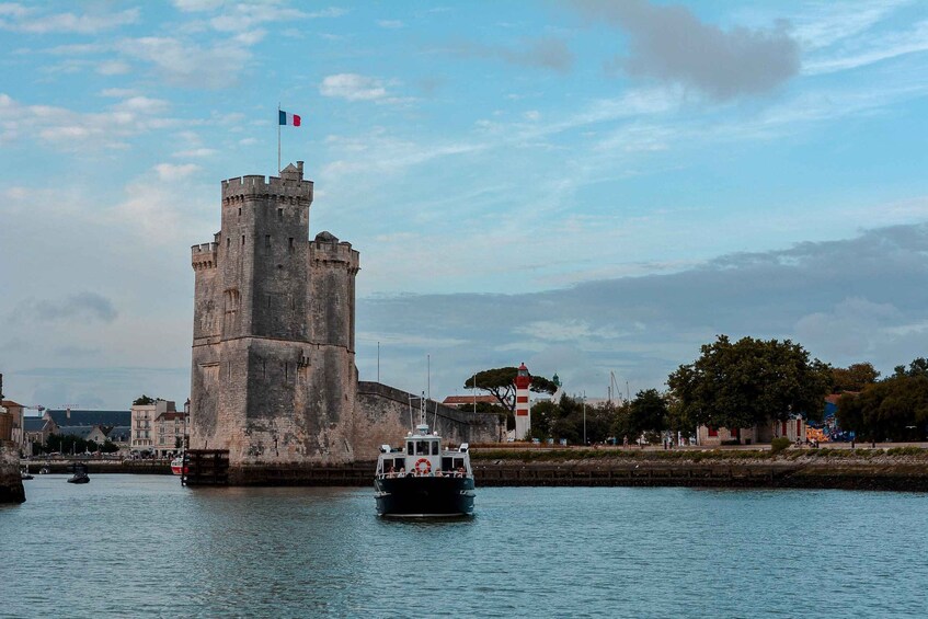 A castle with a flag, a boat, and a lighthouse in the background. 3