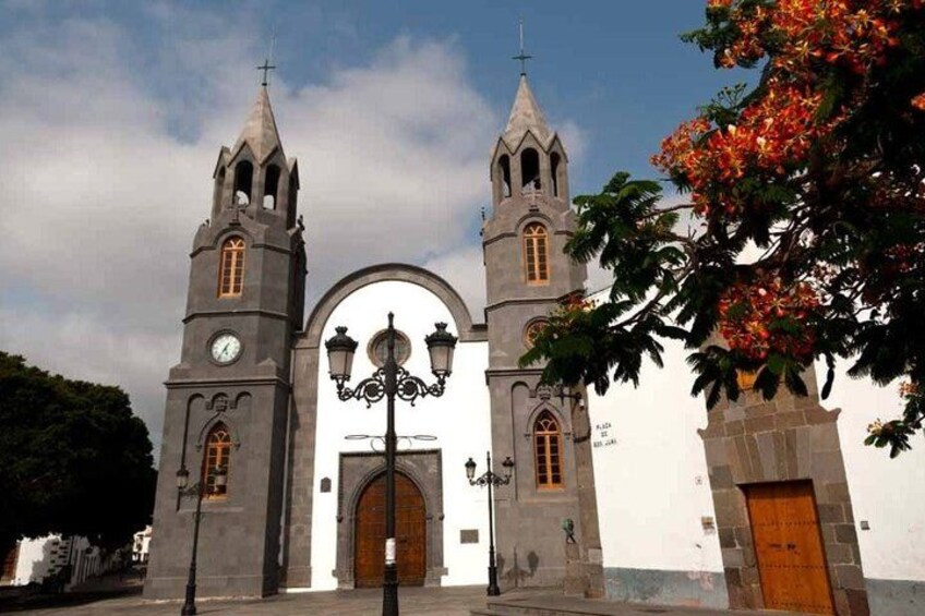 A church with two towers, a large arched entrance, and a street lamp. 5