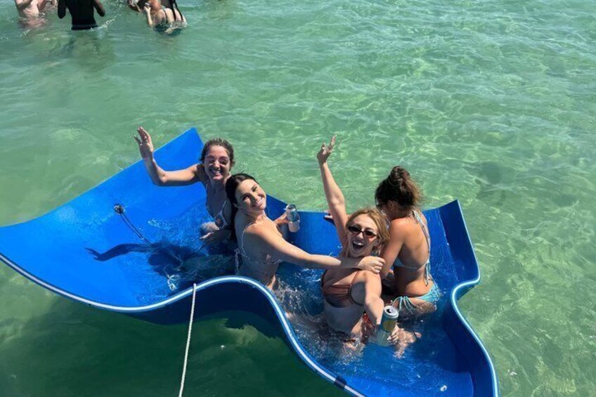 Personas en un tobogán azul sobre aguas cristalinas. 3