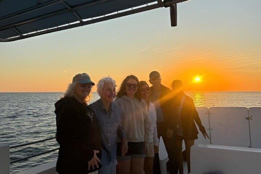 A group of people on a boat during sunset. 1