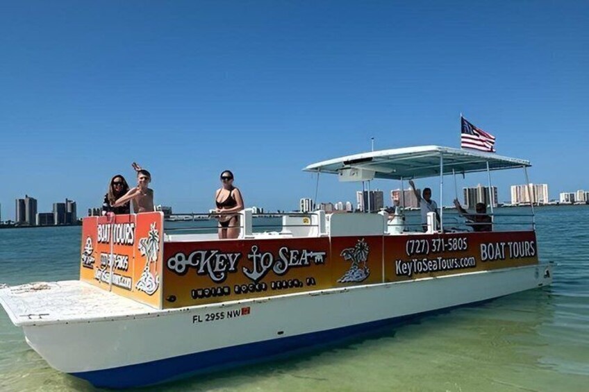 A boat tour with people on board, a city skyline in the background, and a clear blue sky. 3