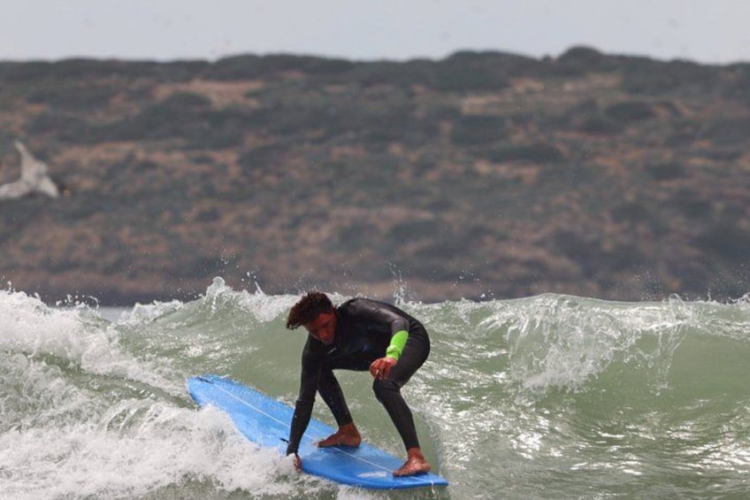 En person surfer på en bølge med en blå surfbræt. 3