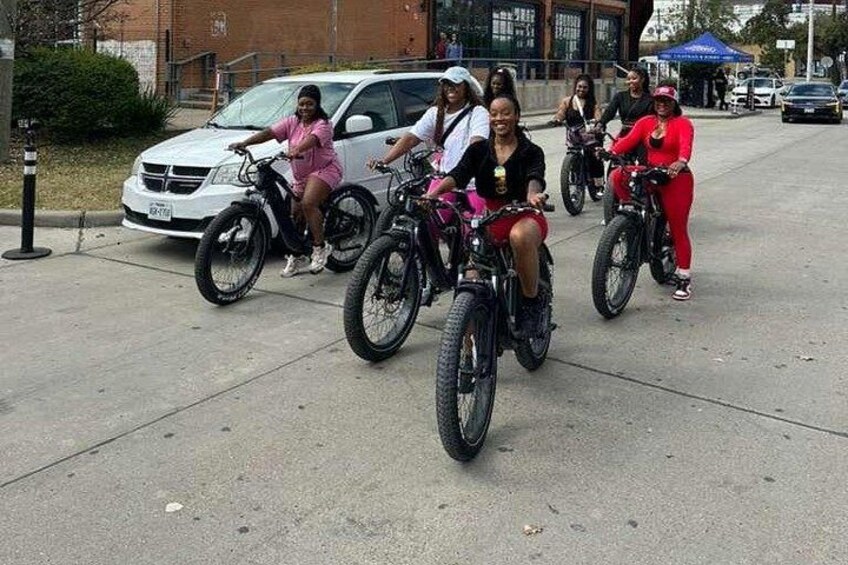 Un gruppo di persone che vanno in bicicletta su una strada cittadina. 1