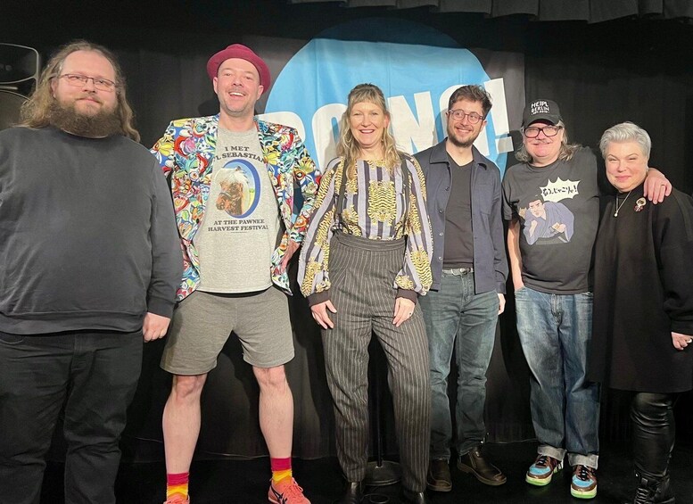 A group of people standing in front of a backdrop with text. 3