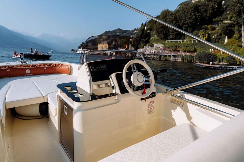 A boat's interior with a steering wheel, control panel, and seating area. 3