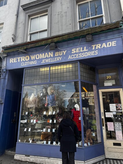 A storefront with a sign reading 'Retro Woman Buy Sell Trade' and displays clothing, jewelry, and accessories. 1