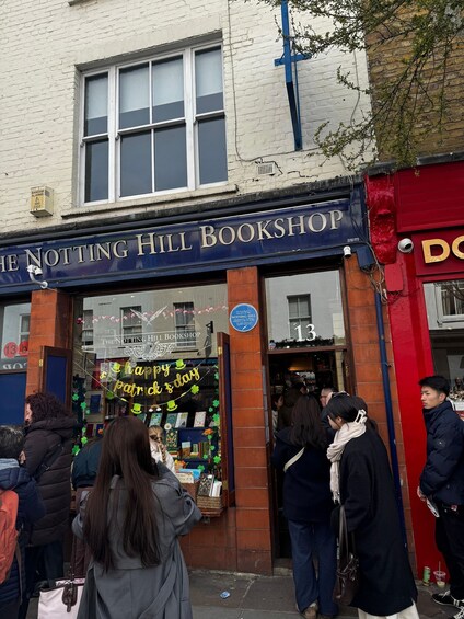 A bookshop with a sign reading 'The Notting Hill Bookshop' and a 'Happy St. Patrick's Day' banner. 2