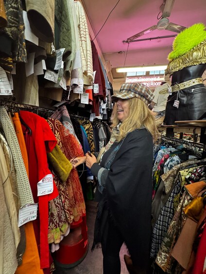 A person browsing through a clothing store with various garments on display. 5