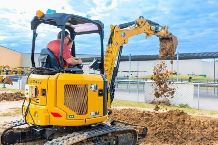 Un'escavatrice gialla con un operatore all'interno che scava del terreno. 3