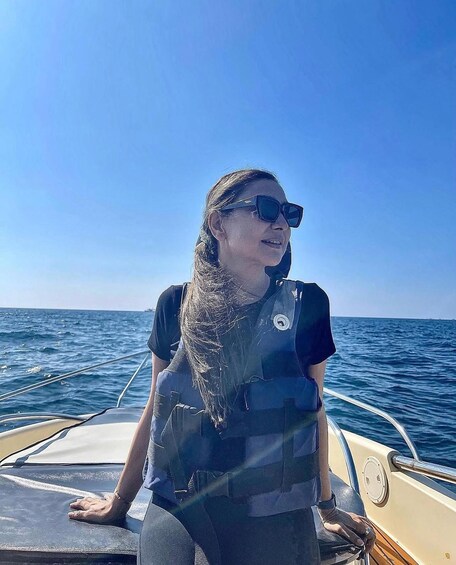 A person on a boat with a clear blue sky and calm sea. 4