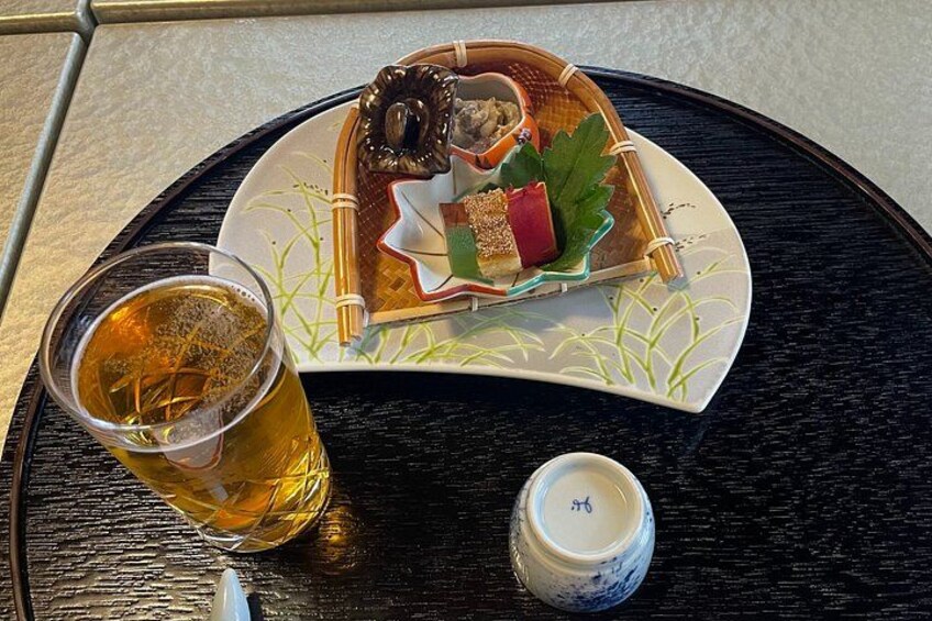 A tray with a plate of food, a glass of tea, and a small container. 4