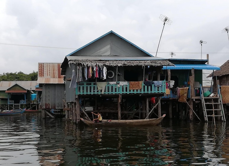 A floating house with a boat in front, surrounded by water. 3