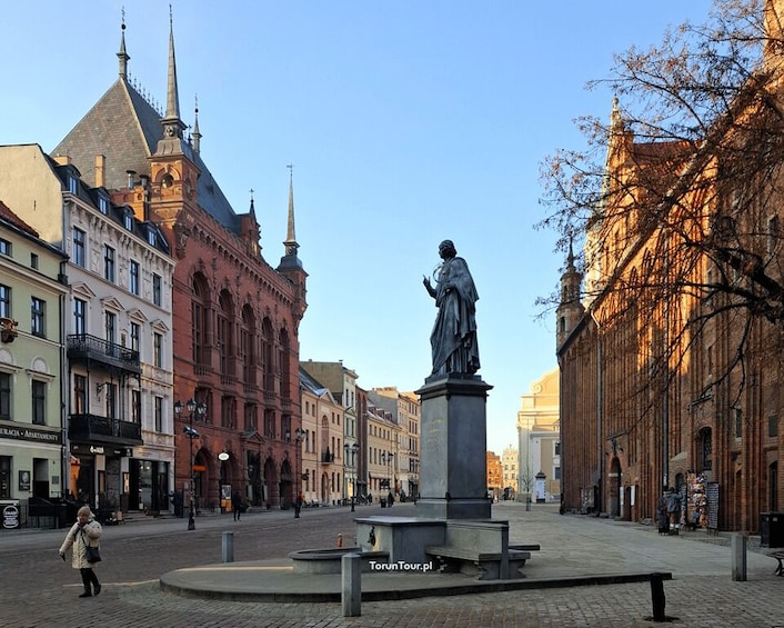 A statue in a square with historic buildings around. 1