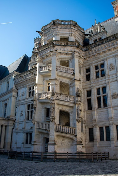 A historic building with ornate architecture, including detailed carvings and a prominent balcony. 4