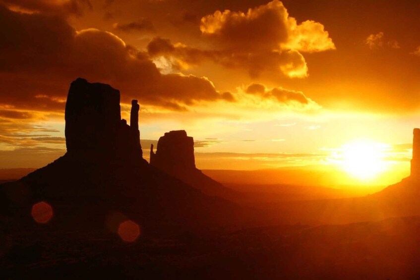 A sunset over a desert landscape with prominent rock formations. 5