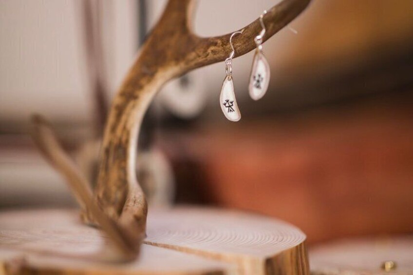 A wooden branch with a carved ornament and a hanging pendant. 3