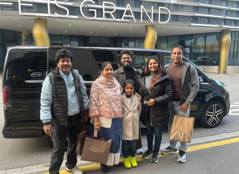 A group of people standing in front of a building with a sign that reads 'ES GRAND.' 4