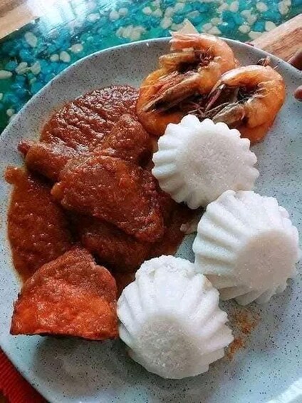 A plate with a red curry, shrimp, and white rice. 4