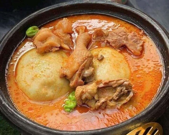 A traditional stew with meat and potatoes in a black pot. 5