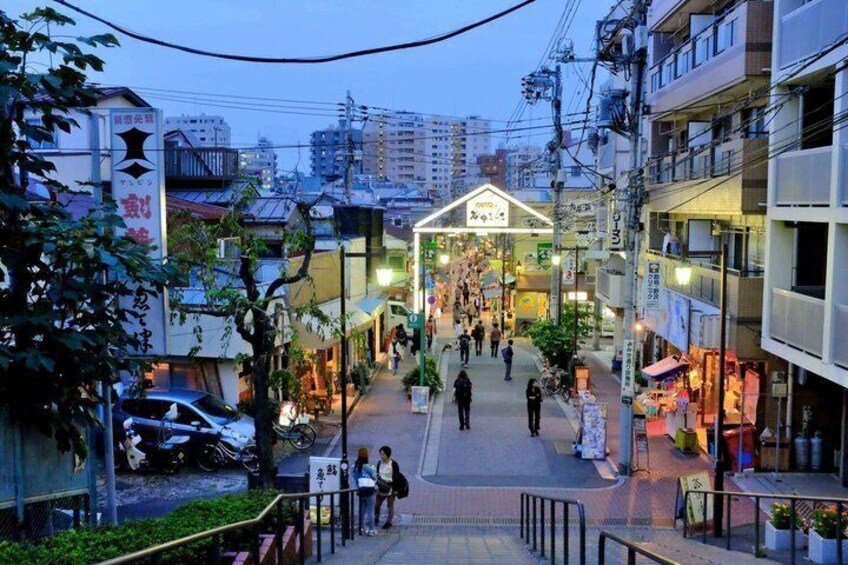 Una animada calle urbana con comercios, peatones y un edificio destacado con un cartel. 3