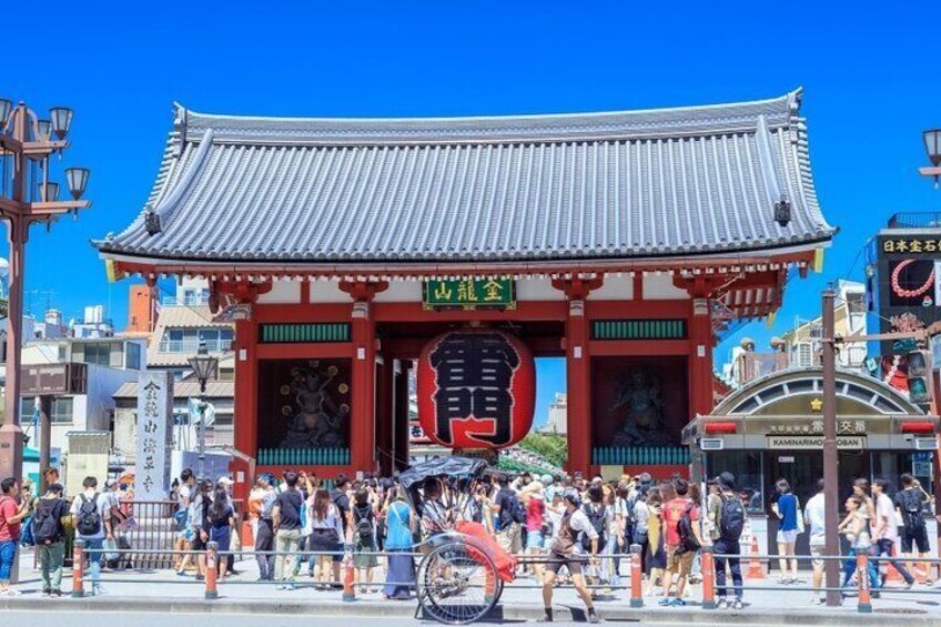 Un torii japonés tradicional de colores rojo y blanco, rodeado de gente. 5