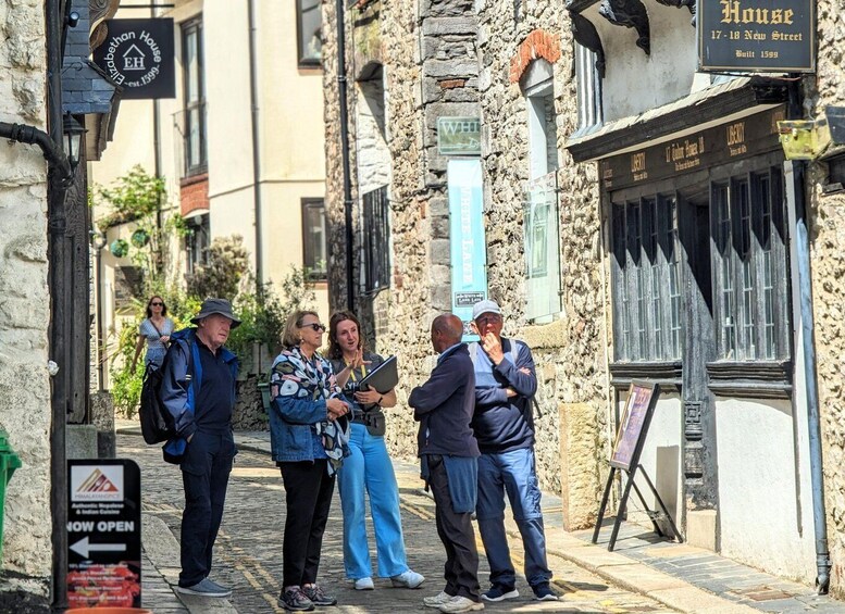 A group of people standing on a cobblestone street, a sign for 'House 17-18 New Street,' and a sign for 'Himalaya Spice.' 2