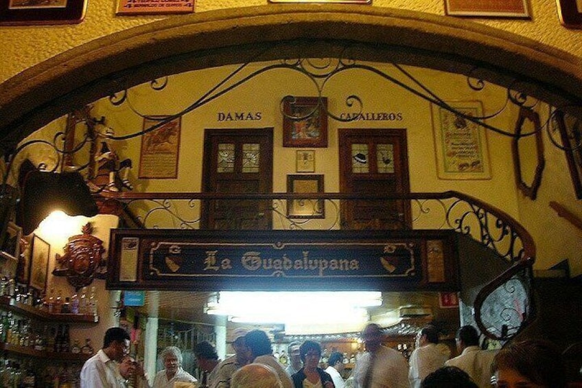 An indoor market with a sign reading 'La Guabelupana' and 'DAMAS' above. 3