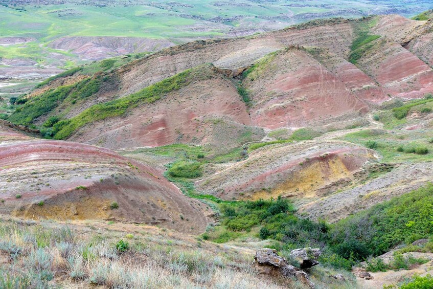 A rugged landscape with layered hills and sparse vegetation. 2